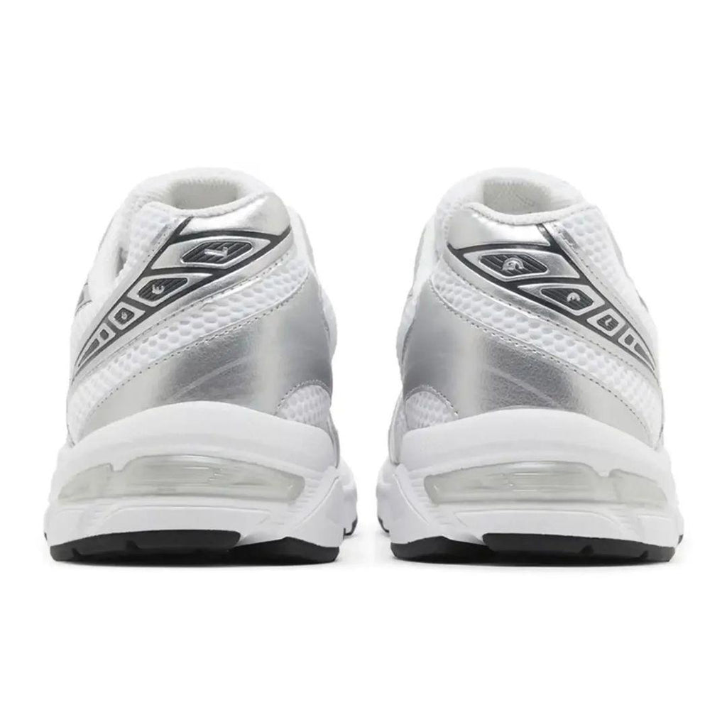 A pair of white and metallic silver athletic sneakers shown from the back, featuring mesh panels, a metallic synthetic upper, and a thick white cushioned sole with a black outsole.