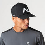 Agaru 'Carbon Black' SRG Cap for men, front view on model of black structured baseball cap with raised Agaru logo badge and SRG side print on the curved brim
