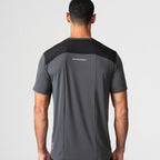 Agaru 'Carbon Black' SRG T-Shirt for men, back view on model showing the black panelled shoulder yoke, reflective back strip and seamless charcoal fabric