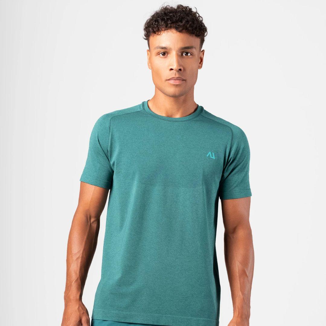 A man wearing a teal athletic short-sleeve t-shirt with a small light blue Agaru sports logo on the left chest, photographed against a light gray studio background.