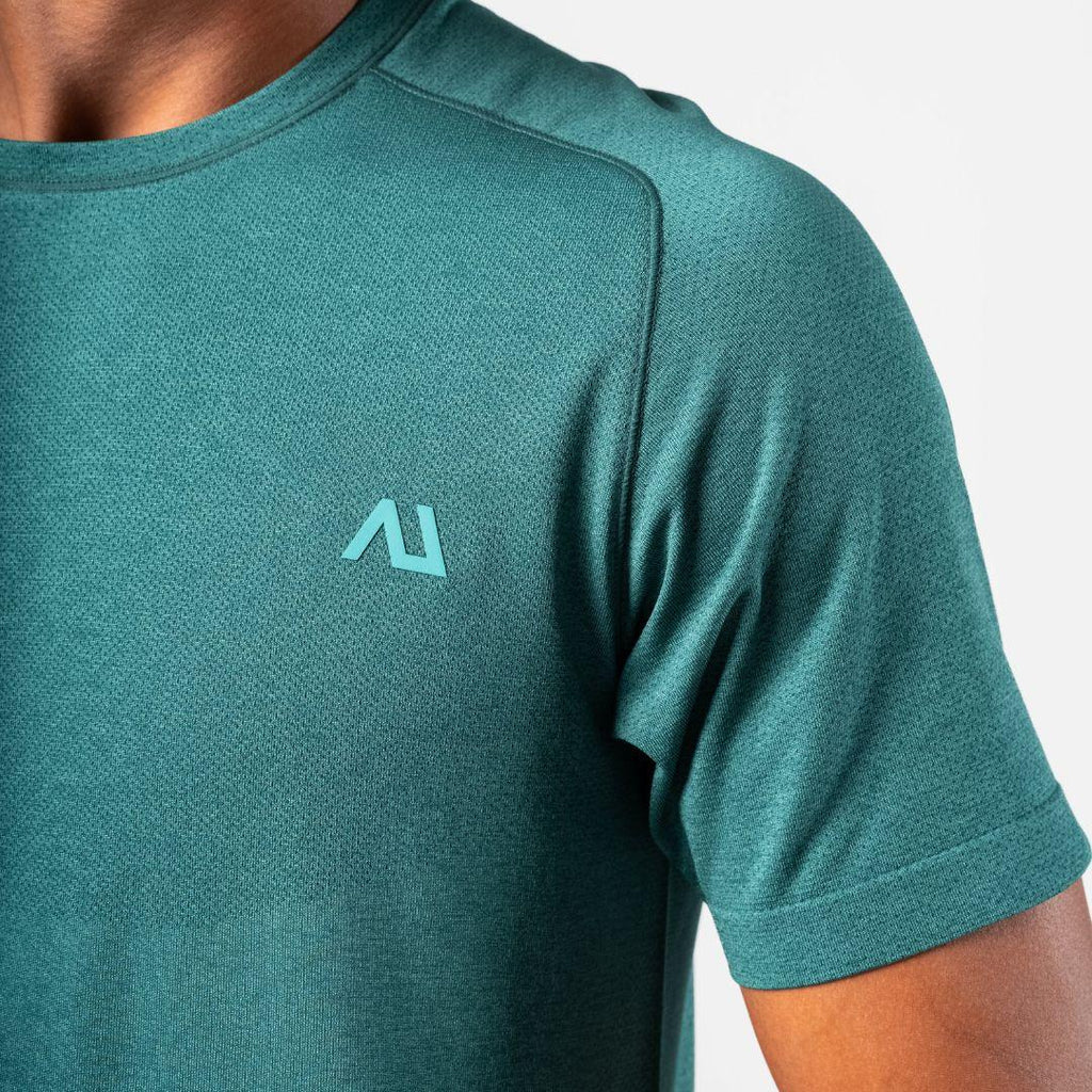 Close-up of a person wearing a teal short-sleeve athletic t-shirt with a light teal stylized 'AU' logo on the left chest, against a light gray background.