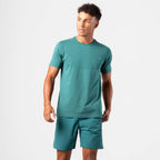 A man modeling a teal green athletic Agaru sports t-shirt and matching shorts against a clean white studio background.
