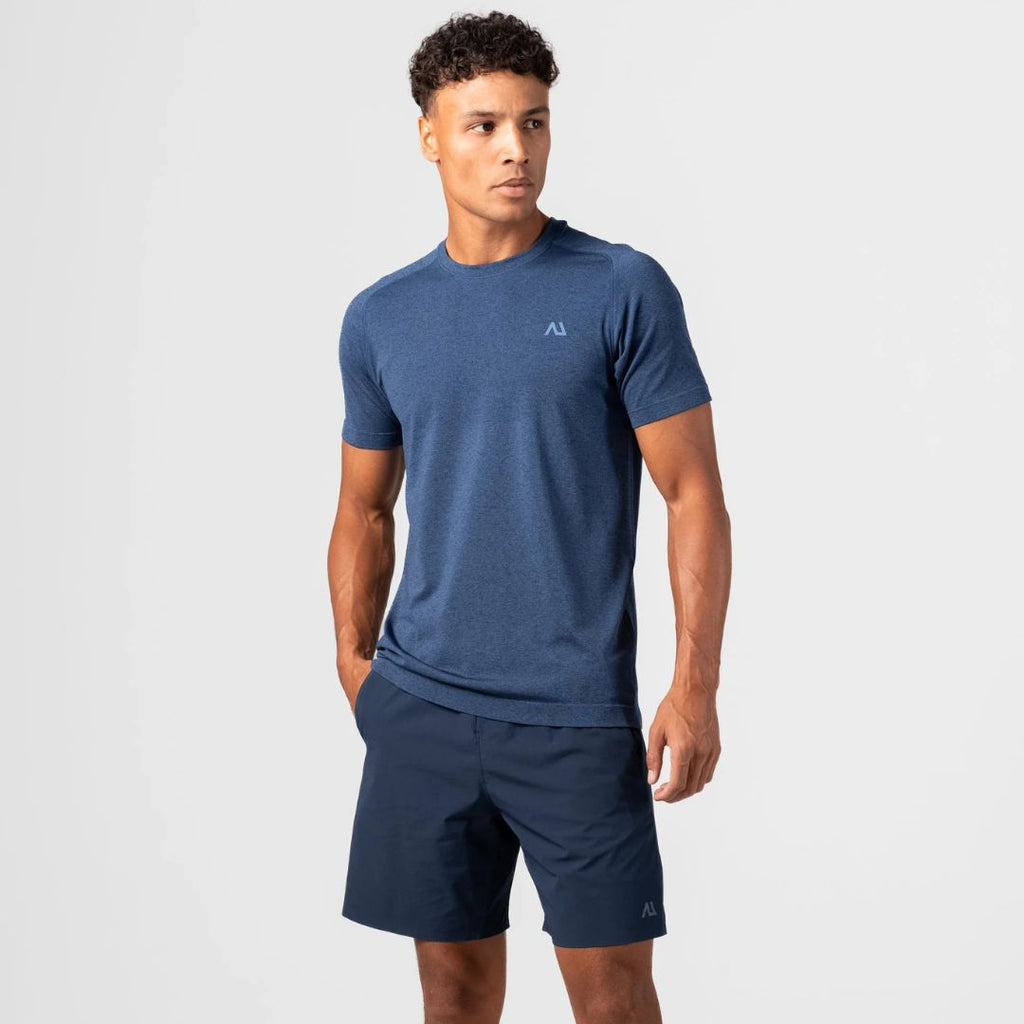 A man modeling a Agaru heathered blue short-sleeve athletic t-shirt and matching navy blue shorts against a light gray studio background.