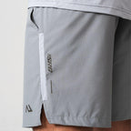 Agaru 'Titanium Grey' SRG Shorts for men, close-up of the zipped side pocket, SRG logo print and Agaru branding on the grey woven shorts