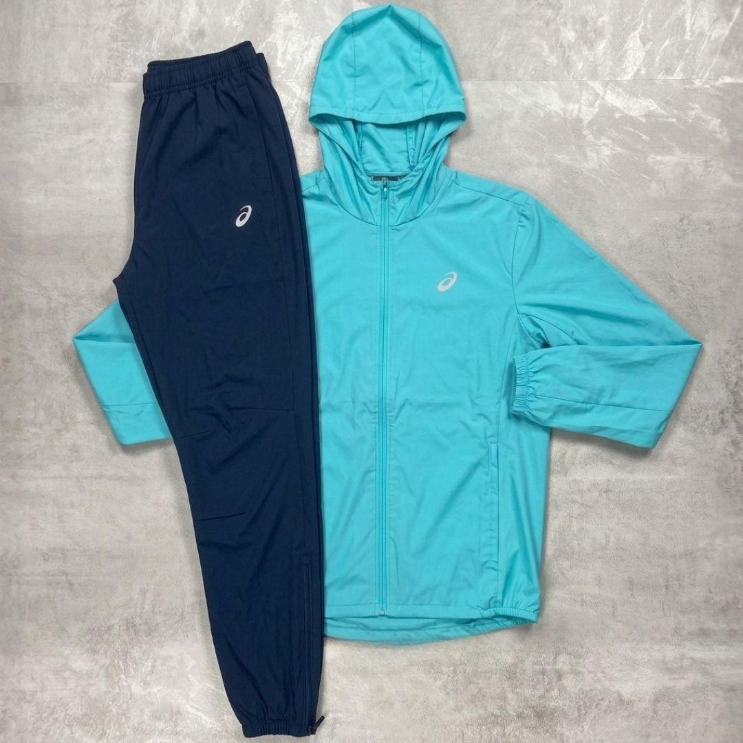 Asics 'Aqua' Core Windrunner and Pant Tracksuit for men, flat lay of aqua full-zip hooded jacket and matching navy woven pant with Asics branding