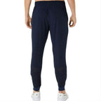 Asics Navy Core Woven Pant for men, back view on model showing the tapered fit, part of the Aqua Core Windrunner and Pant Tracksuit