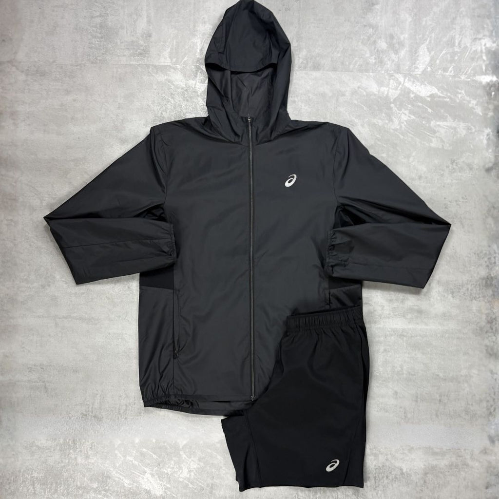 Black jacket and shorts set with a Asics logo on a grey surface