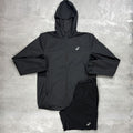 Black jacket and shorts set with a Asics logo on a grey surface