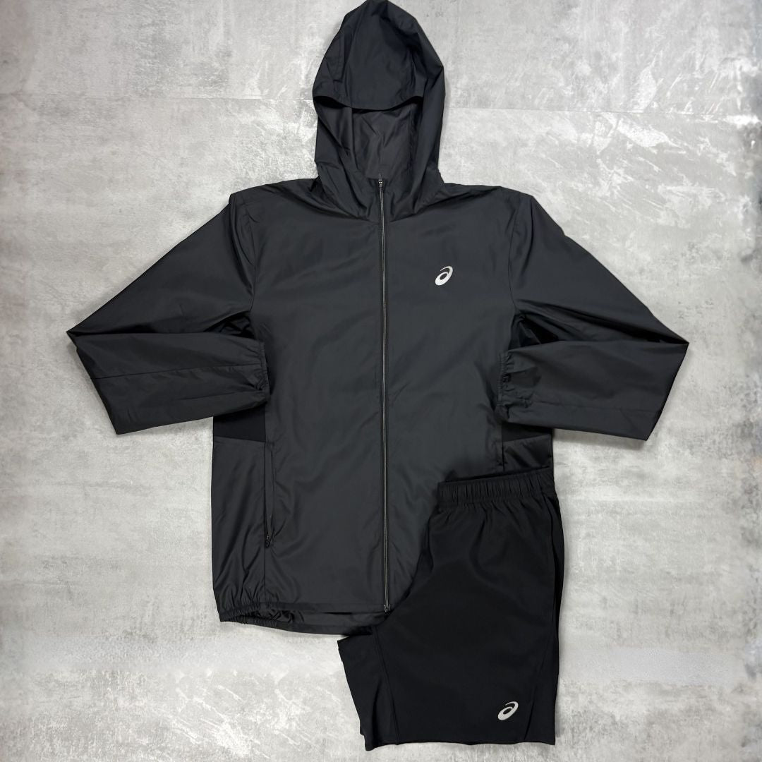 Black jacket and shorts set with a Asics logo on a grey surface