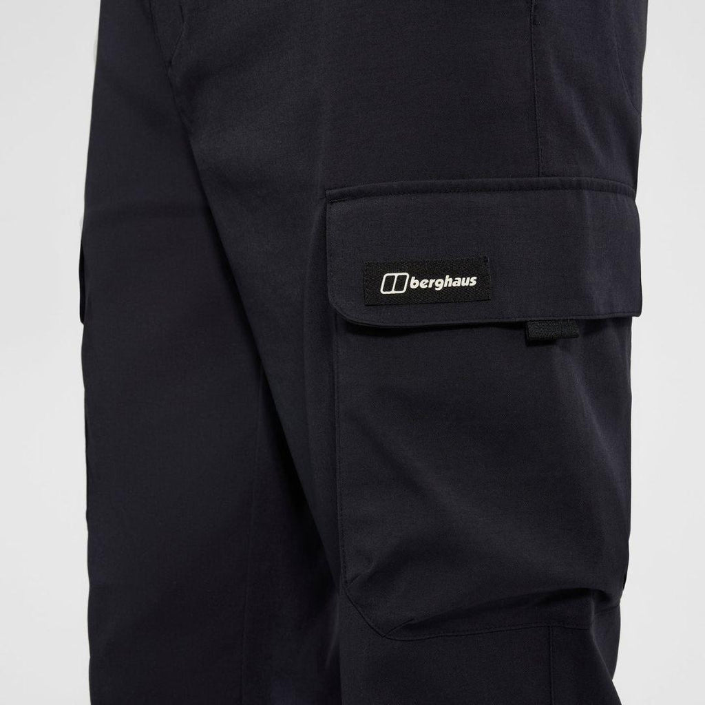 Berghaus Black Everyday Cargo Pant for men, close-up on model of the black flap thigh cargo pocket with tab closure and woven Berghaus logo label