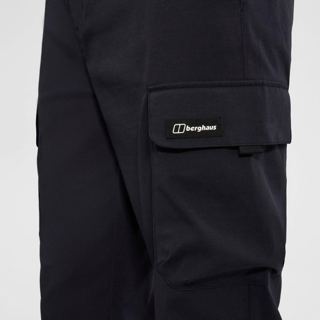 Berghaus Black Everyday Cargo Pant for men, close-up on model of the black flap thigh cargo pocket with tab closure and woven Berghaus logo label