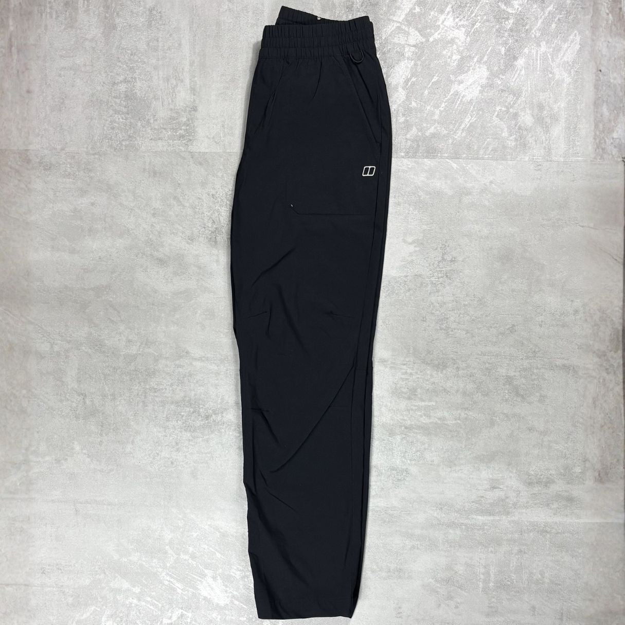 Berghaus Black bottoms layed flat on a grey concrete floor