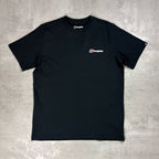 A black short-sleeve crewneck t-shirt with a small Berghaus logo printed on the left chest, laid flat on a textured gray concrete background.