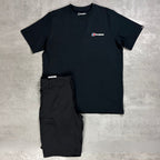 A black short-sleeve t-shirt with a small red, white, and blue chest Berghaus logo and matching black cargo shorts, laid flat on a textured gray concrete background.