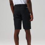 A man wearing black outdoor cargo shorts, shown from a rear three-quarter angle against a light gray studio background.