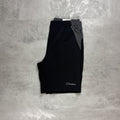 Black shorts with a Berghaus logo on a gray concrete surface