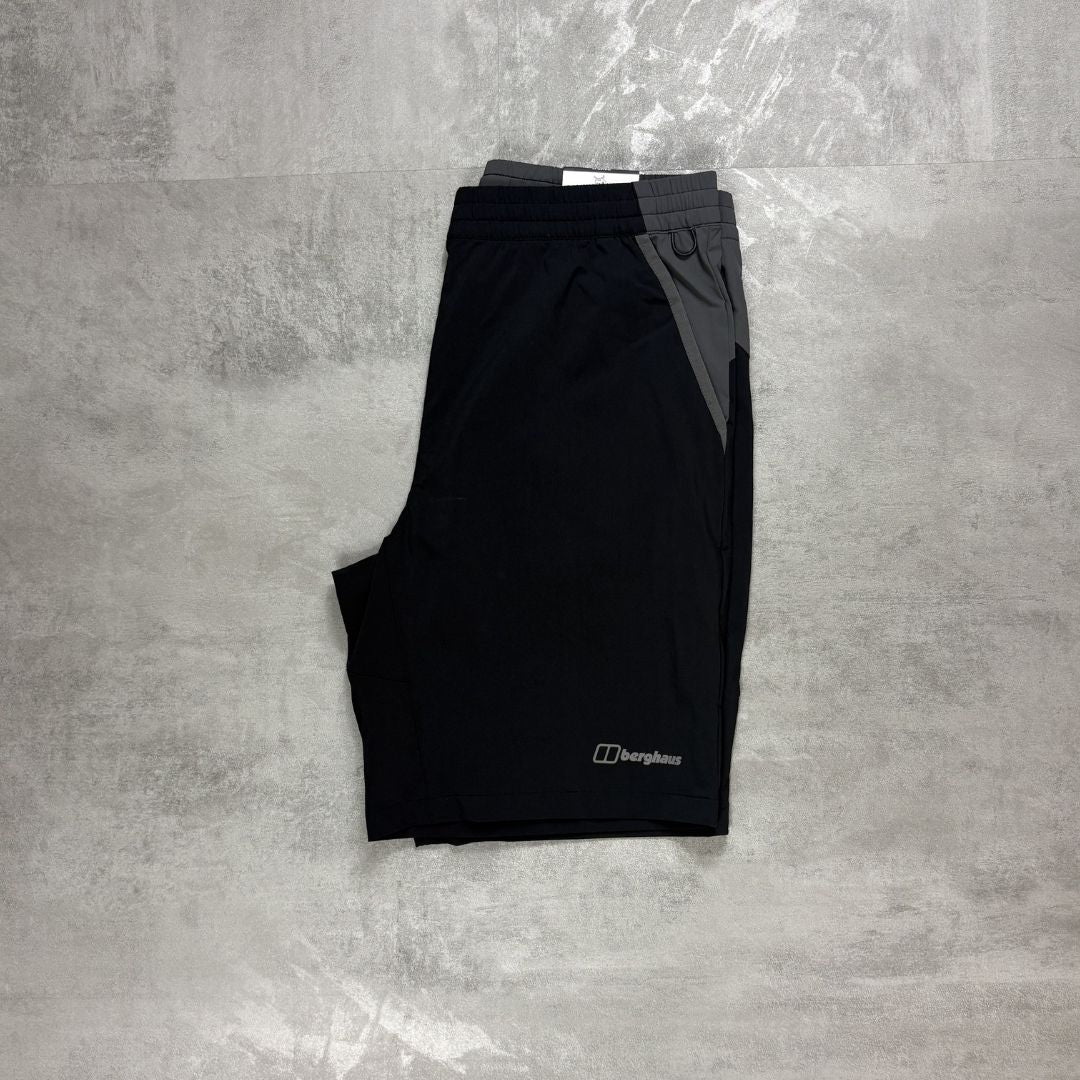 Black shorts with a Berghaus logo on a gray concrete surface