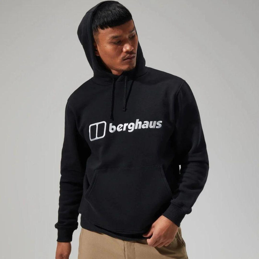 Berghaus Black Logo Hoodie for men, front view on model of black pullover hoodie with drawcord hood, kangaroo pocket and Berghaus logo across the chest, part of the Black Logo Hoodie, Tee & Pant Tracksuit