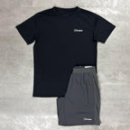 A two-piece athletic set from Berghaus, featuring a black short-sleeve performance t-shirt and dark gray shorts, laid flat on a textured gray concrete surface.