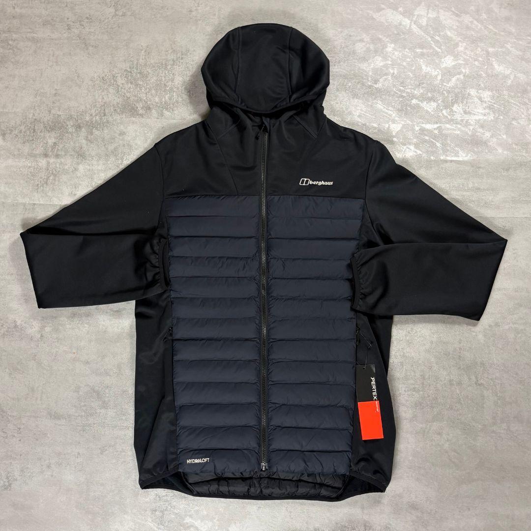 Berghaus Black Vaskye Hooded Hybrid Jacket for men, flat lay on a grey concrete surface of the black full-zip hooded jacket with quilted centre panel and smooth sleeves