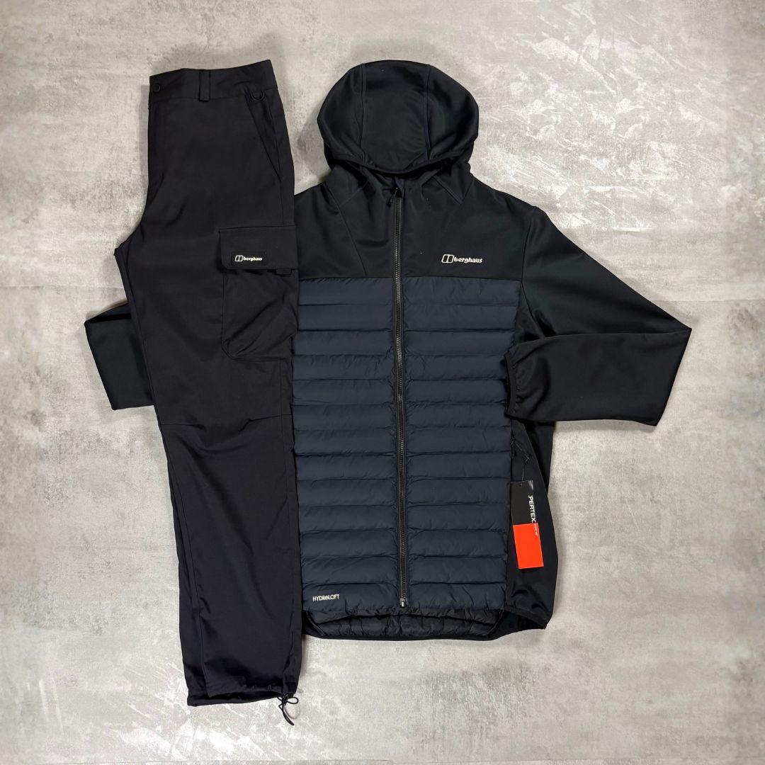Berghaus Black Vaskye Hooded Hybrid Jacket & Cargo Pant Tracksuit for men, flat lay on a grey concrete surface of the black hooded hybrid jacket with quilted centre panel and matching black cargo pant