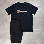 Berghaus Black logo T-shirt paired with Black Navigator shorts on a grey concrete backdrop.