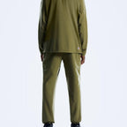A person shown from the back wearing an olive green Berghaus matching tracksuit, consisting of a long-sleeve top and straight-leg pants, against a light gray studio background.