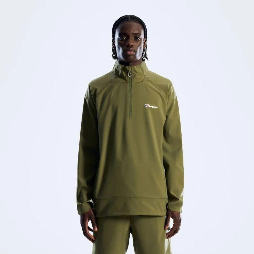 A model wearing a sage green quarter-zip pullover and matching sweatpants against a light gray studio background. The pullover features a small white Berghaus logo on the left chest.