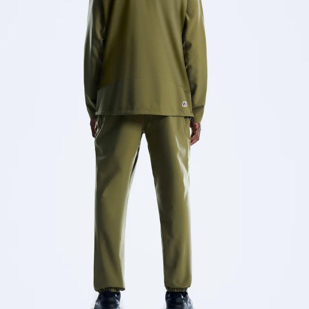 A model shown from the back wearing an olive green athletic tracksuit, featuring a long-sleeve top and matching pants, against a light gray studio background.