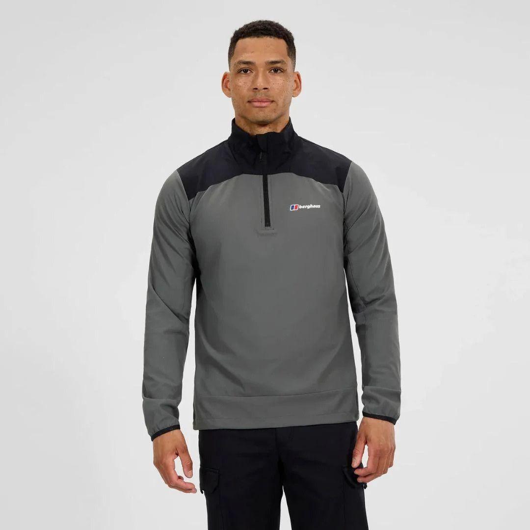 Man wearing a Berghaus grey and black pullover with a visible brand logo on a light gray background
