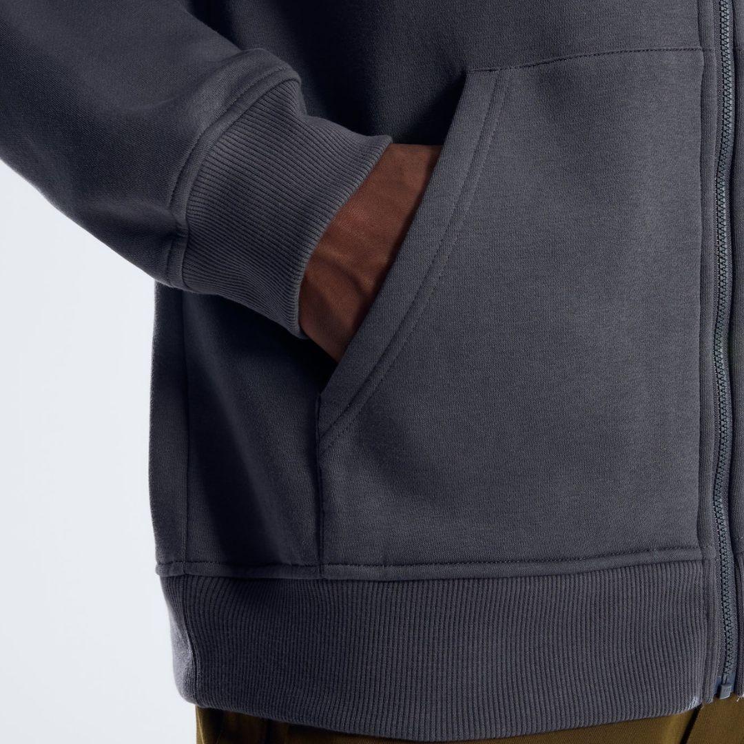 Berghaus 'Dark Grey' Logo Zip-Up Hoodie for men, close-up on model of the front hand pocket and ribbed hem of the dark grey zip-up hoodie