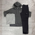 Berghaus 'Dark Grey' Logo Zip-Up Hoodie, Tee & Cargo Pant Tracksuit for men, flat lay on a grey concrete surface of the dark grey full-zip hoodie, grey marl logo tee and black cargo pant