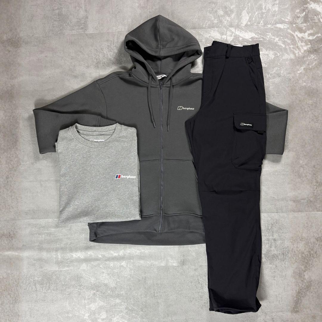 Berghaus 'Dark Grey' Logo Zip-Up Hoodie, Tee & Cargo Pant Tracksuit for men, flat lay on a grey concrete surface of the dark grey full-zip hoodie, grey marl logo tee and black cargo pant