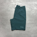 Teal shorts with a Berghaus logo on a gray textured surface