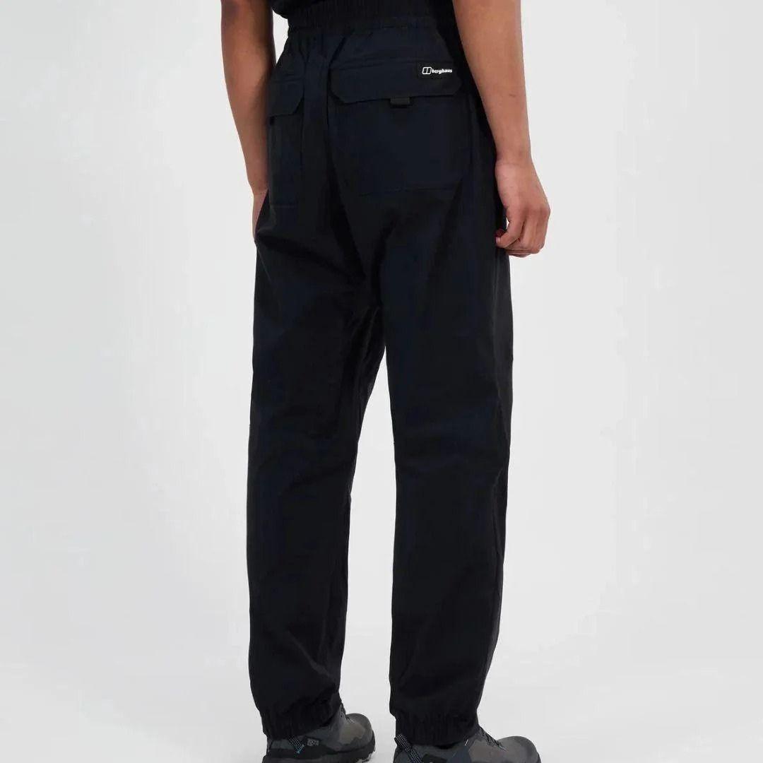 Person wearing black Berghaus pants on a white background