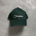 Green cap with Berghaus logo on a gray surface