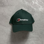 Green cap with Berghaus logo on a gray surface
