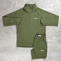 An olive green two-piece tracksuit set from the brand Berghaus, featuring a half-zip pullover jacket and matching drawstring shorts, laid flat on a textured gray background.