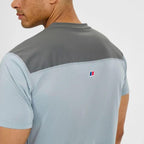Person wearing a two-tone gray and light blue shirt with a Berghaus logo on a white background