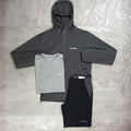 Gray and black hoodie, t-shirt, and pants with Berghaus logo on a textured gray surface