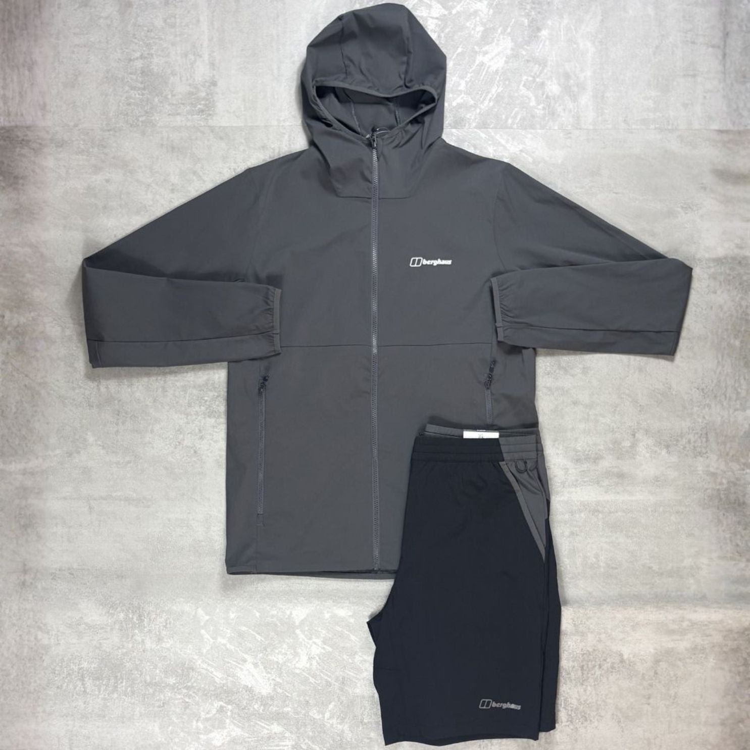 Dark gray jacket and black pants with a Berghaus logo on a light gray background
