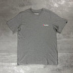 Berghaus Grey Class Logo T-Shirt for men, flat lay on a grey concrete surface of the grey marl crew neck tee with small Berghaus logo on the chest and woven tab on the sleeve