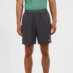 A man wearing dark gray athletic shorts and a green tank top, shown from the waist down against a plain light gray studio background. A small Berghaus logo is visible on the lower left leg of the shorts.