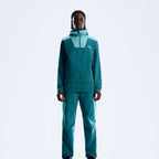 A model wearing a matching Berghaus teal and light blue outdoor tracksuit with a hooded jacket and pants, standing against a plain white studio background.