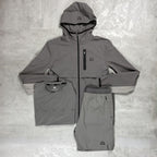 Flux Grey athletic jacket, shirt, and shorts set on a textured gray surface
