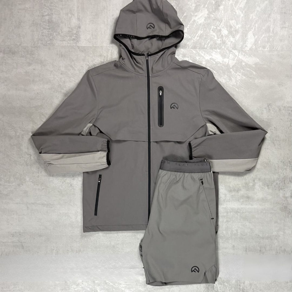 Flux Grey raincoat and pants set on a textured gray background