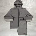 Flux Grey raincoat and pants set on a textured gray background