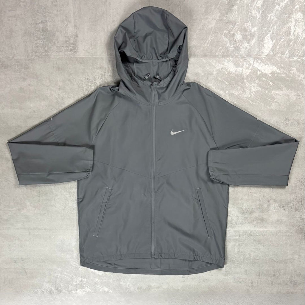 Gray hooded jacket with Nike logo on a textured surface