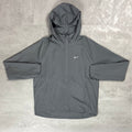 Gray hooded jacket with Nike logo on a textured surface